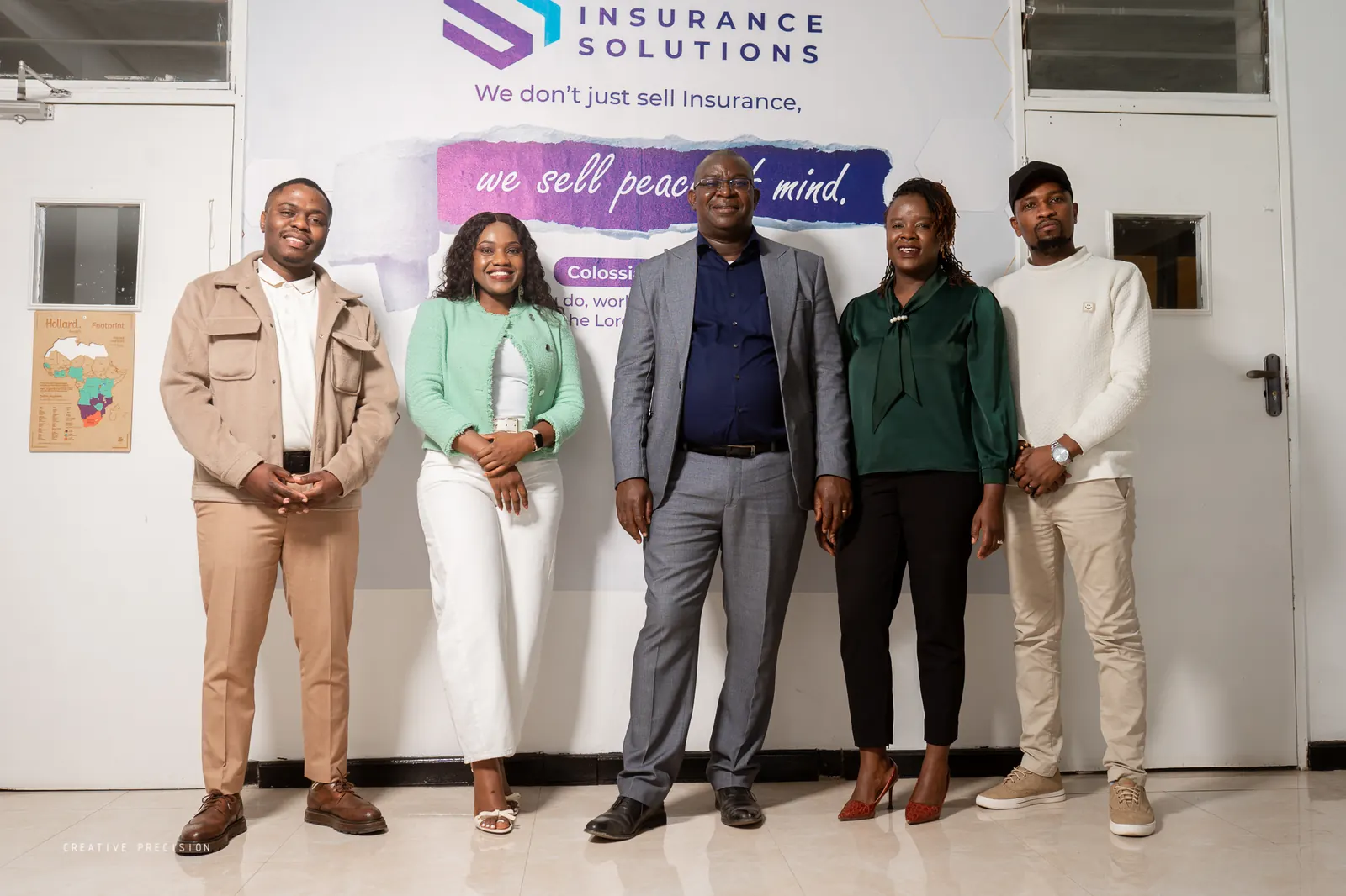 The Symmetric team in front of the company brand wall